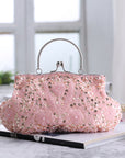 This is an image of a pink clutch purse. The clutch features a sleek and shiny silver exterior with a delicate chain strap. It is a stylish accessory, perfect for adding a touch of sophistication to any evening outfit.