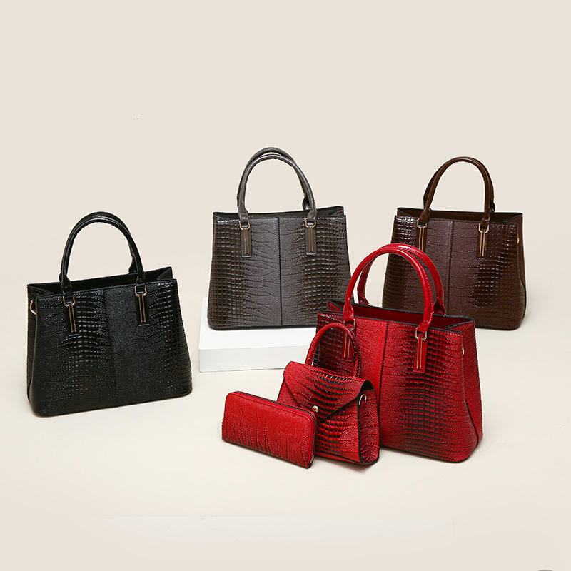 Three-piece crocodile-textured faux leather bag set featuring a spacious tote bag with sturdy handles, a compact mini handbag with a stylish flap closure, and a matching wallet. The set exudes elegance with its bold red color and sophisticated crocodile pattern, perfect for various occasions.