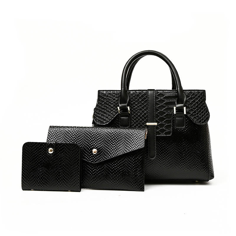 Premium black leather handbag set featuring a spacious handbag with snake-embossed details, an envelope-style clutch, and a compact wallet, all designed with textured finishes and metallic accents, displayed against a clean white background.