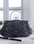 An elegant black satin evening clutch with a shimmering crystal-encrusted clasp, perfect for adding a touch of glamour to your formal attire