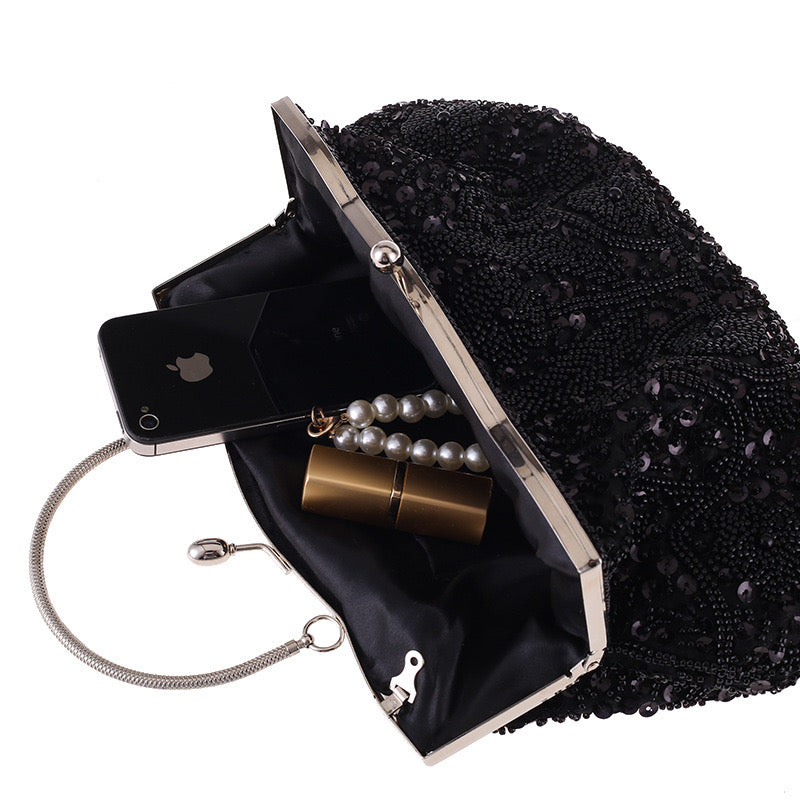This image depicts the interior of a clutch. The inside reveals a compact yet organized space with pockets and compartments for essentials such as a phone, keys, and makeup. It is a functional and stylish accessory for keeping your belongings neatly arranged during a night out or formal event.