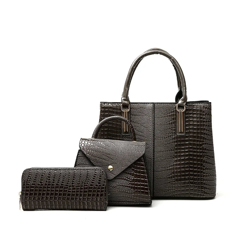 Three-piece grey crocodile-textured faux leather bag set featuring a spacious tote bag with sturdy handles, a compact mini handbag with a stylish flap closure, and a matching wallet. The set exudes elegance with its bold red color and sophisticated crocodile pattern, perfect for various occasions.