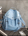 Functional denim shoulder bag with water-resistant lining and padded laptop sleeve