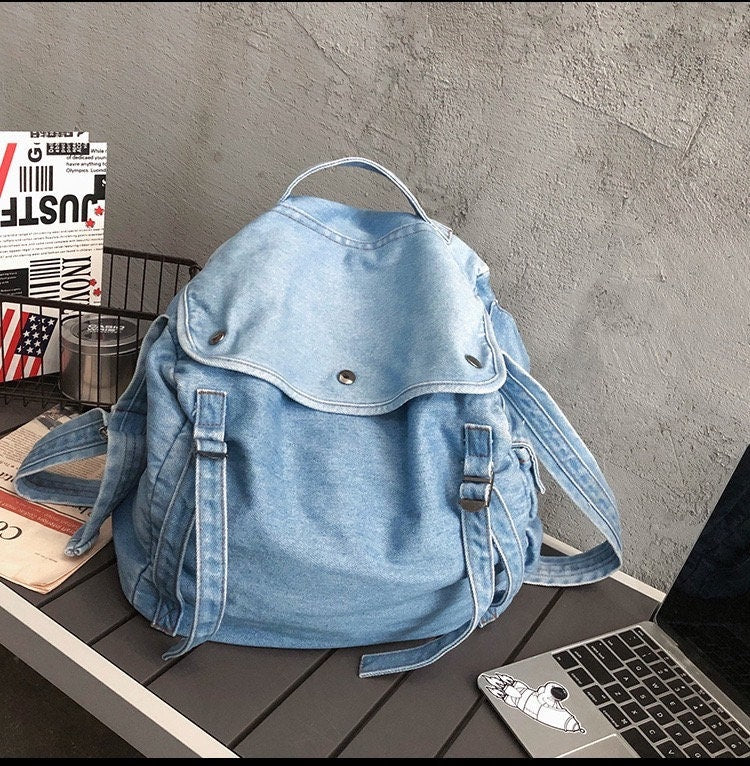 Functional denim shoulder bag with water-resistant lining and padded laptop sleeve